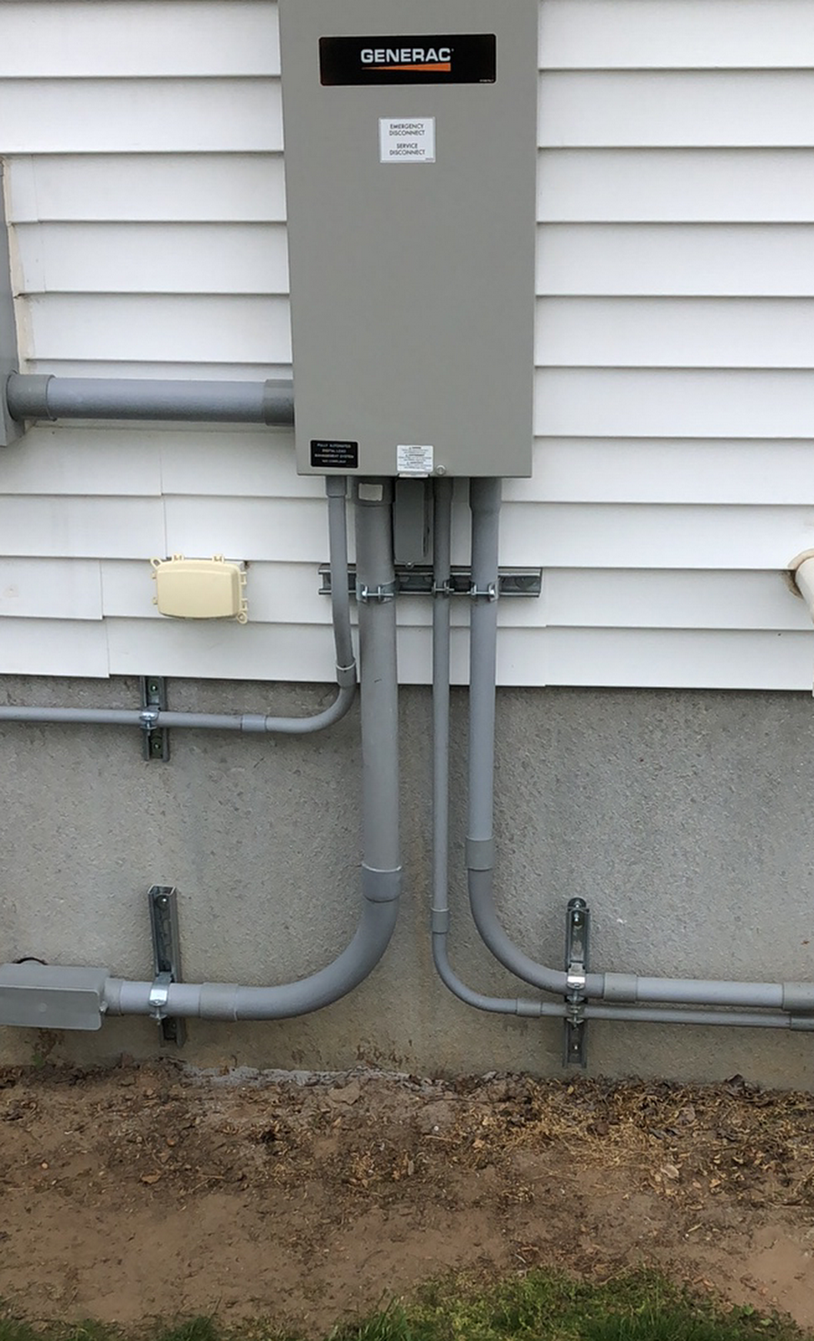 A gray box is attached to the side of a house.