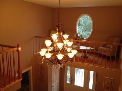 A large chandelier is hanging from the ceiling in a living room.