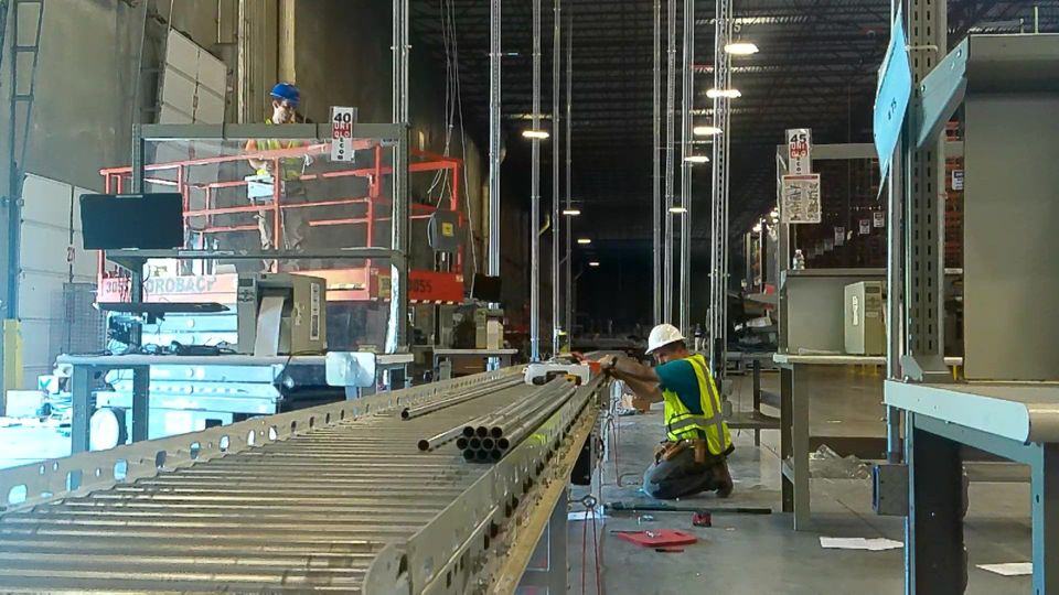 A man is working on a conveyor belt in a warehouse.