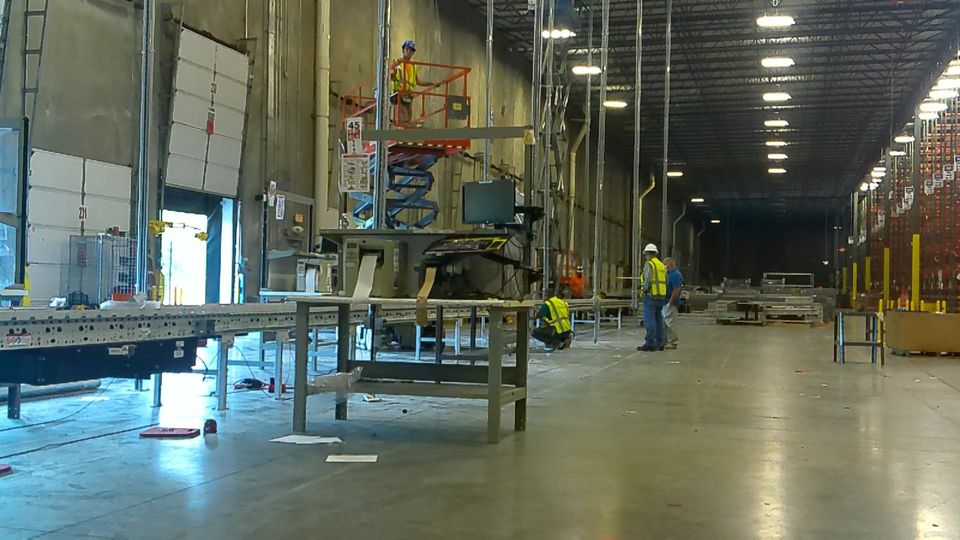 A warehouse with workers working on a conveyor belt