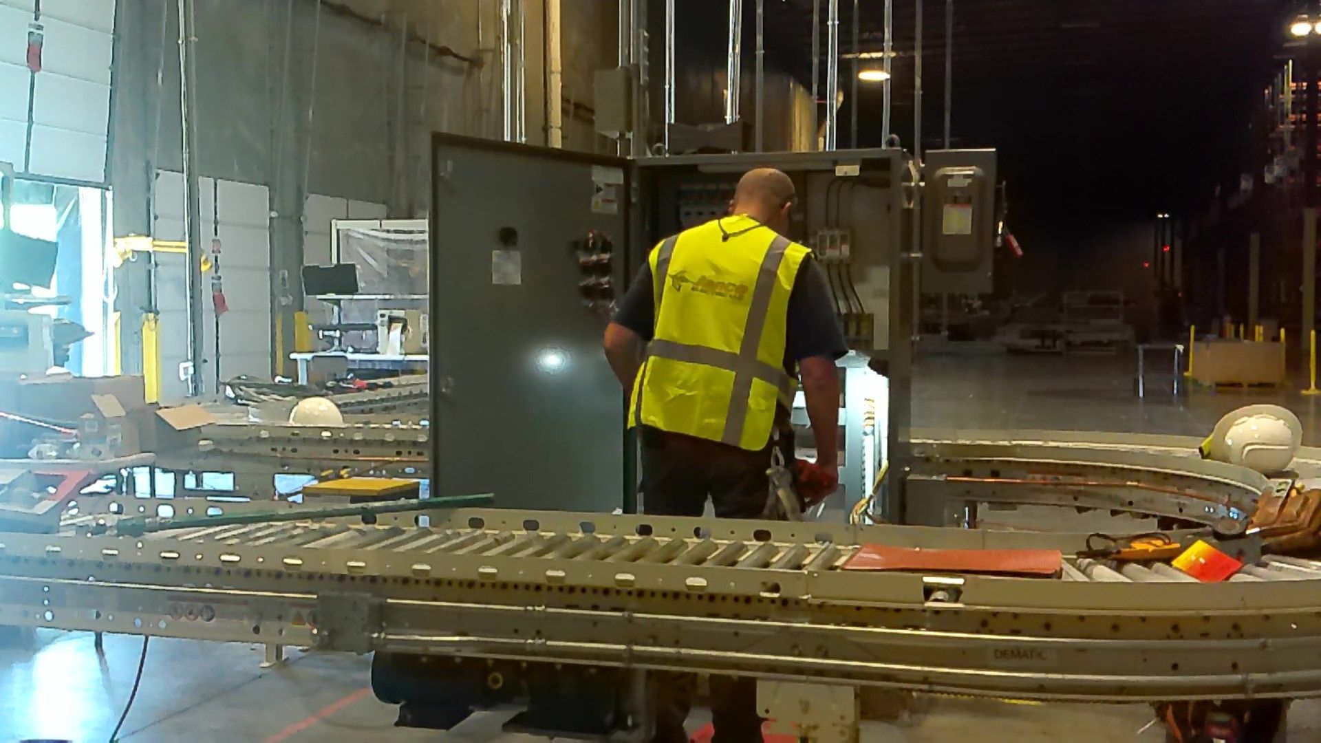 A man in a yellow vest is working on a machine
