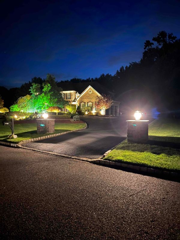 A house is lit up at night with lots of lights in front of it.