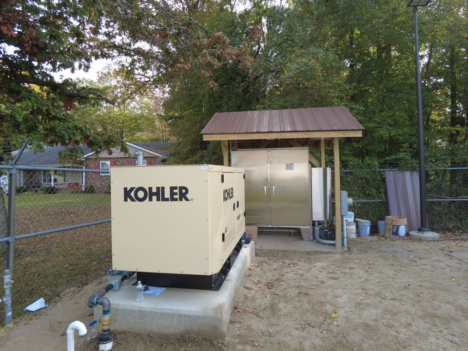 A kohler generator is sitting in a dirt area