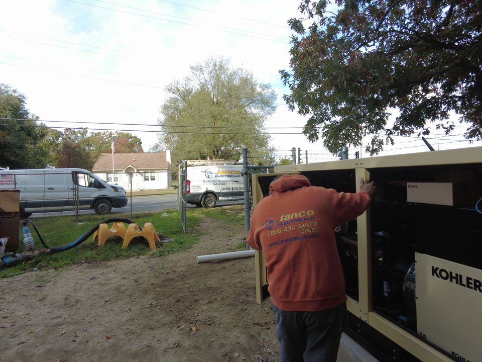 A man in an orange jacket is working on a kobelco generator