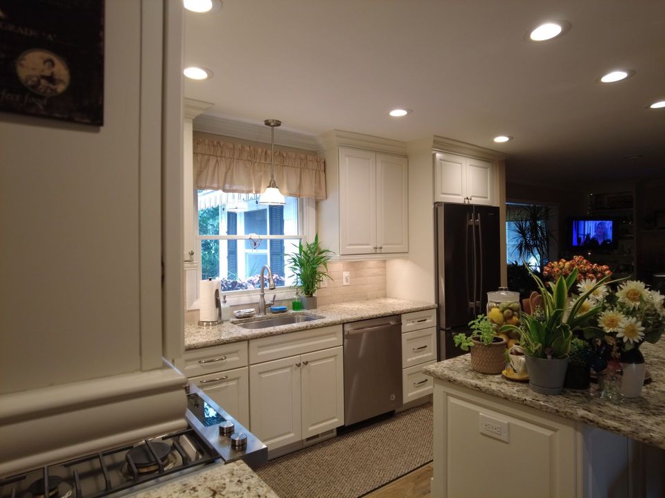 A kitchen with white cabinets , granite counter tops , stainless steel appliances , and a stove.