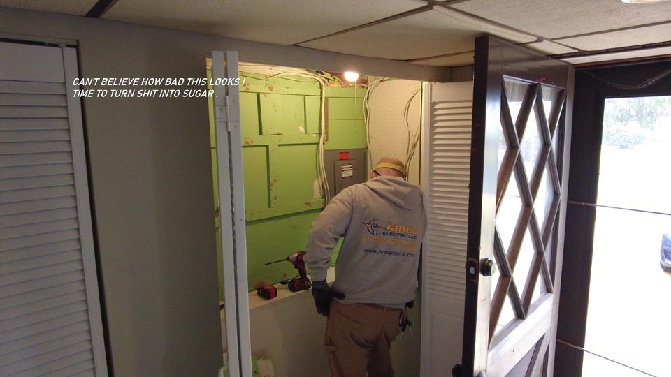 Worker painting a green wall inside a doorway, with white trim and an open security gate nearby.