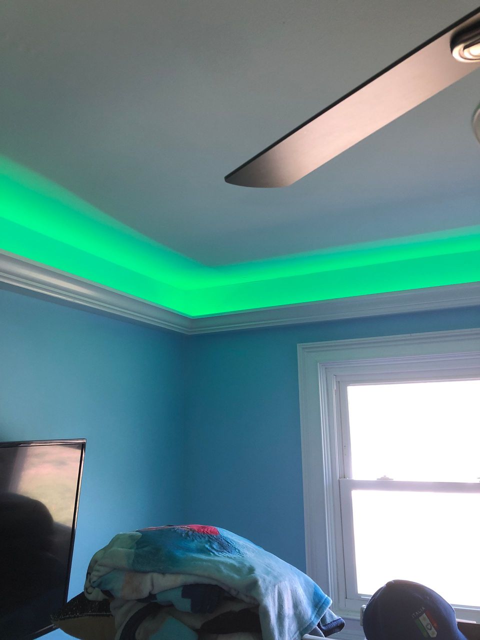 A room with blue walls and a green light on the ceiling