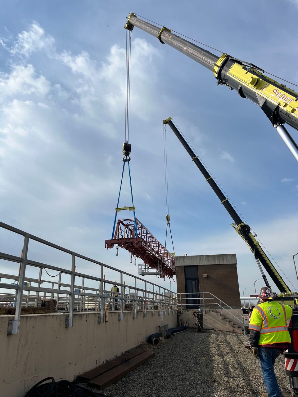 A crane is lifting a bridge over a railing