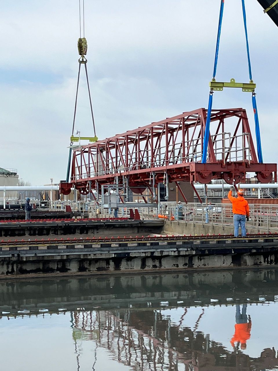 A crane is lifting a bridge over a body of water
