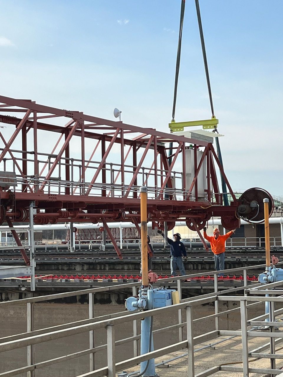 A large metal structure is being lifted by a crane.