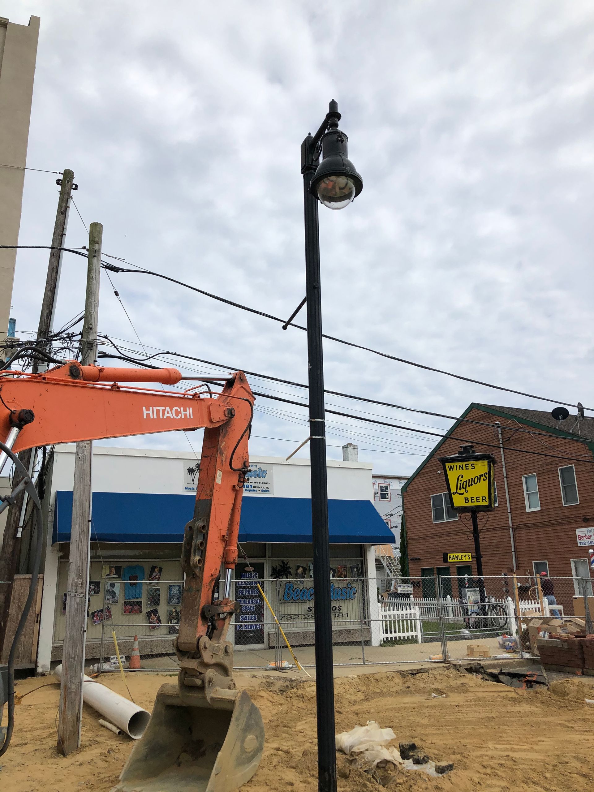 An excavator is digging a hole in the ground in front of a building.