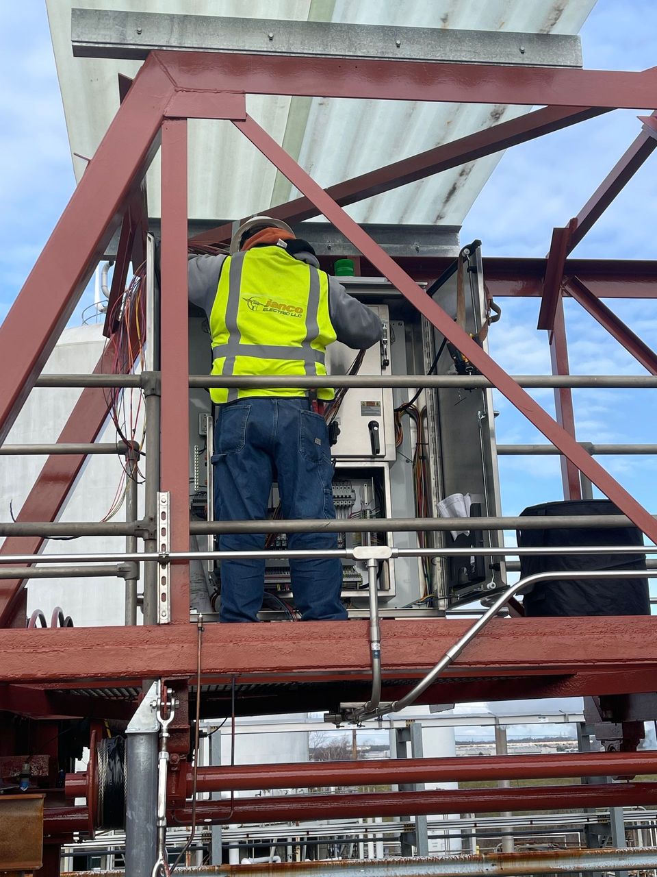 A man wearing a yellow vest that says ' eee ' on it
