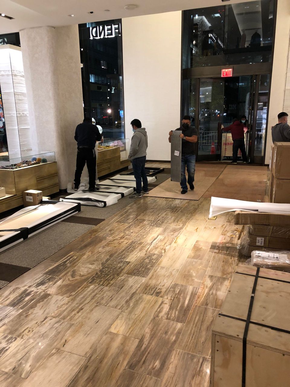 A group of men are standing in a room with boxes on the floor.