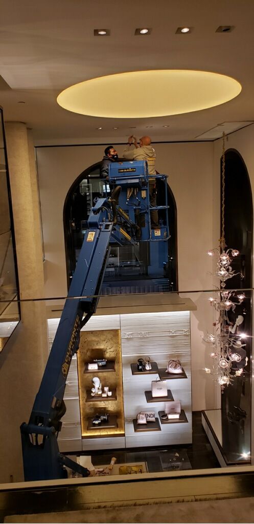 A man is standing on a crane in a store.