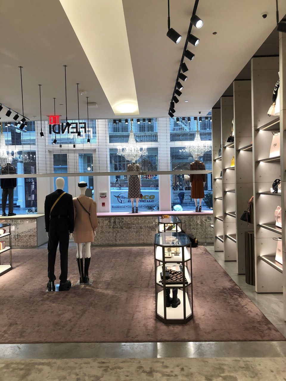 A couple standing in a store with a red exit sign above them
