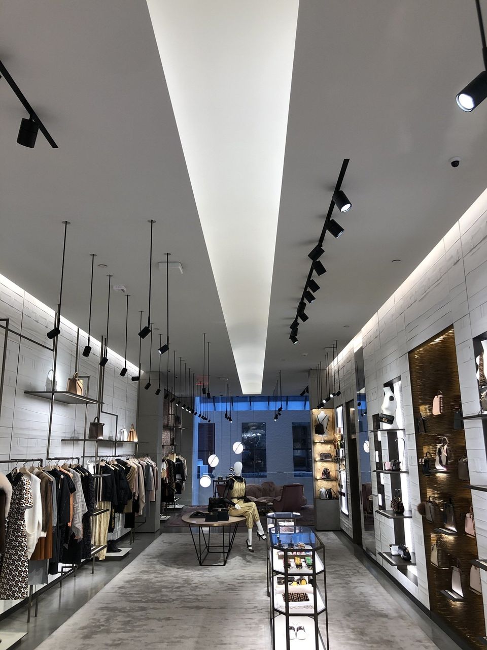 The inside of a clothing store with a ceiling that is very high.