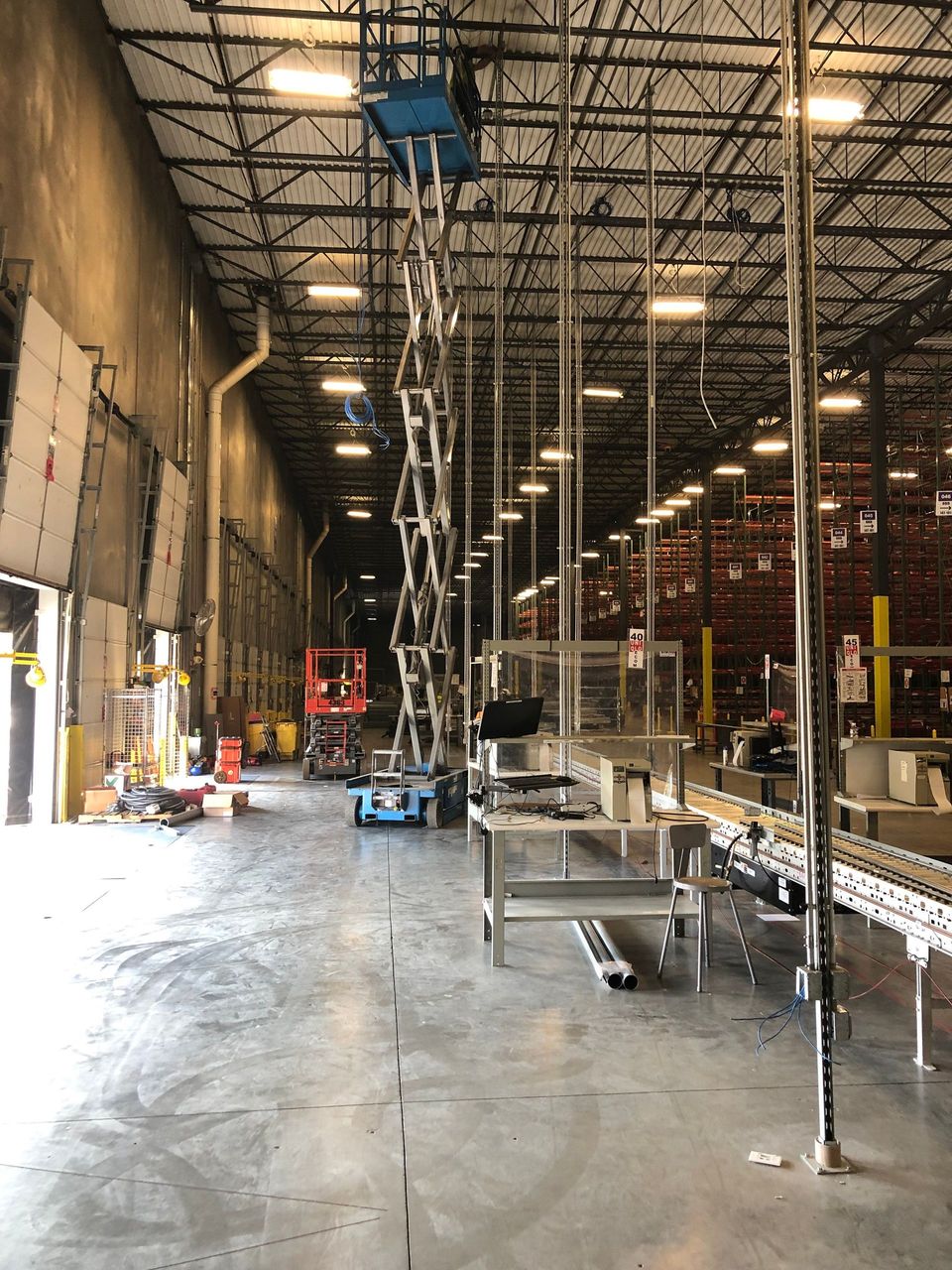A large warehouse with a ladder hanging from the ceiling.