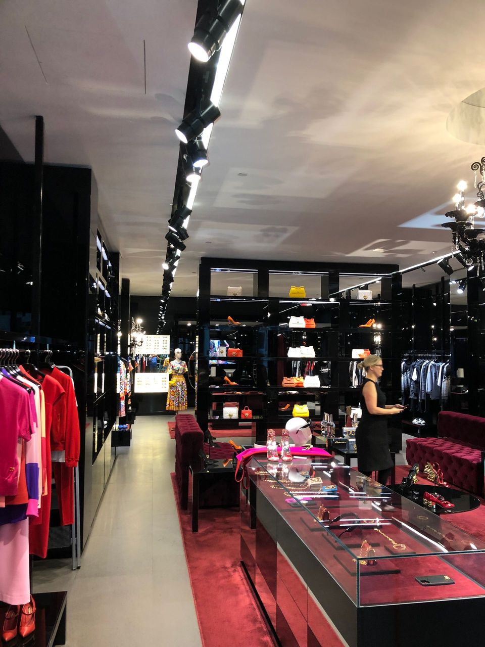 A woman in a black dress is standing in a clothing store