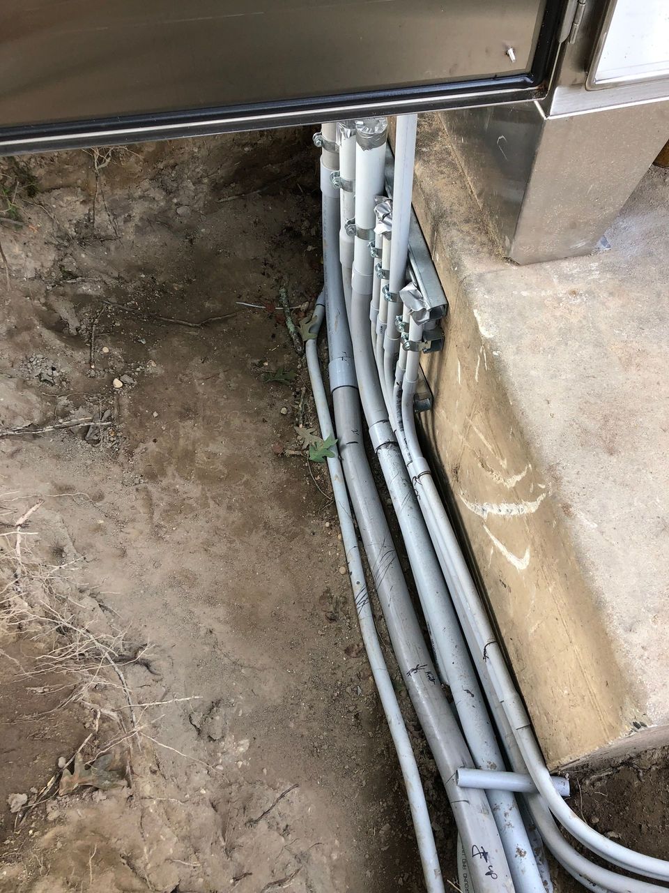 A bunch of wires are laying in the dirt.