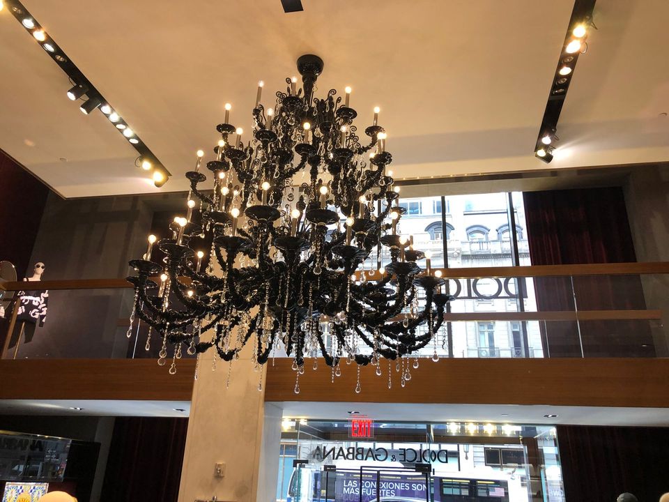 A large black chandelier hangs from the ceiling of a store