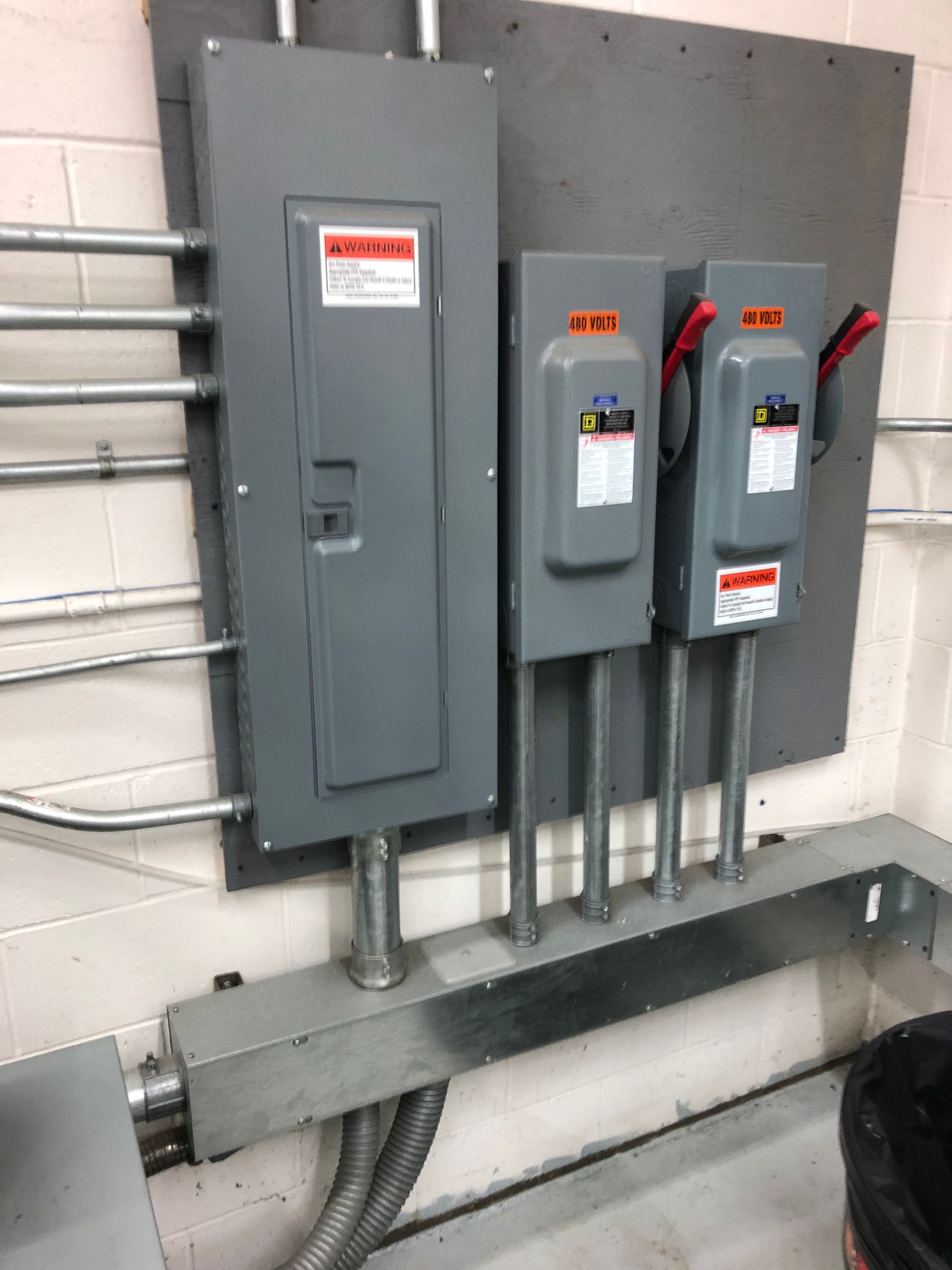 A couple of electrical boxes are hanging on a wall.