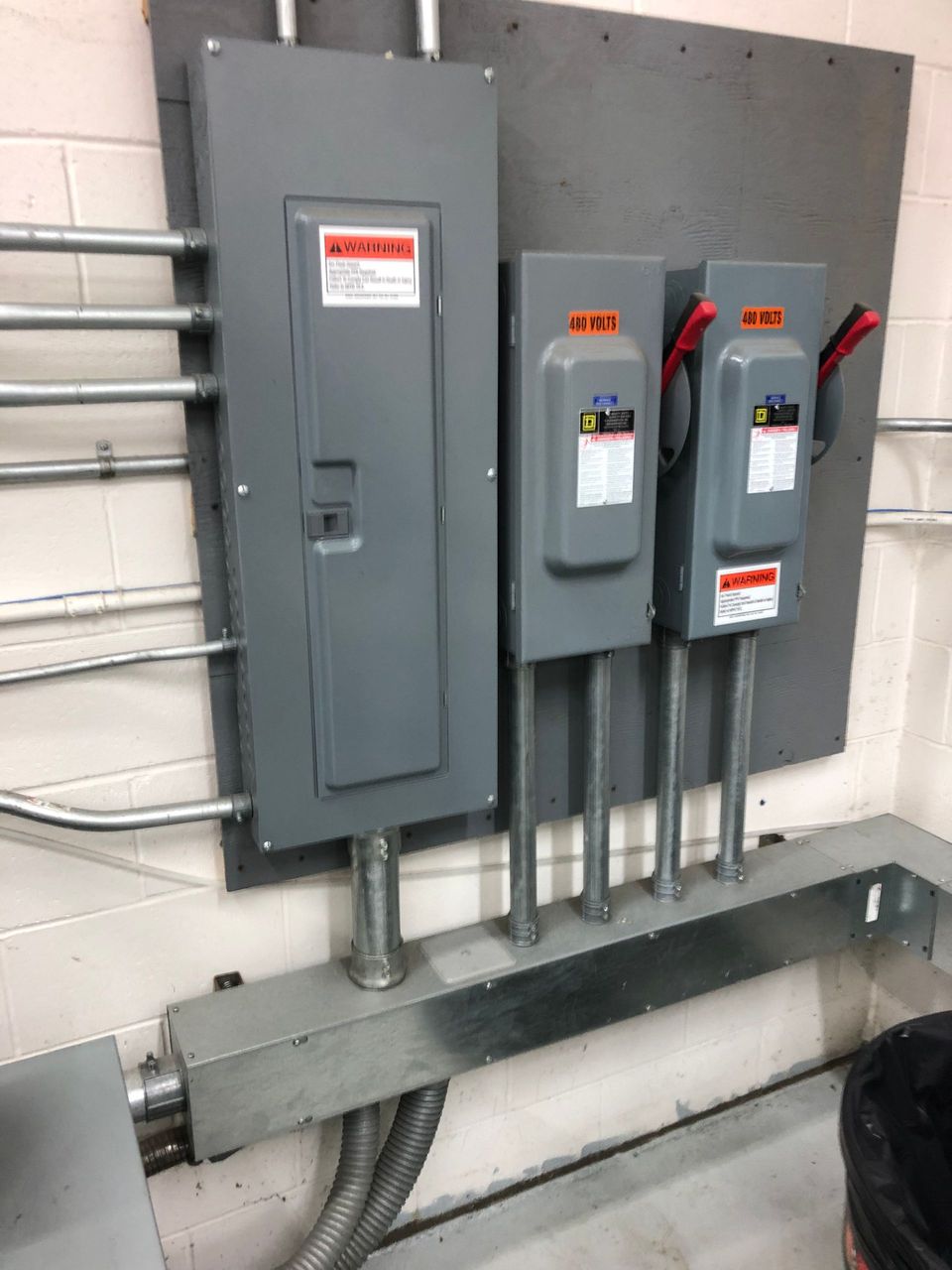 A couple of electrical boxes are hanging on a wall.