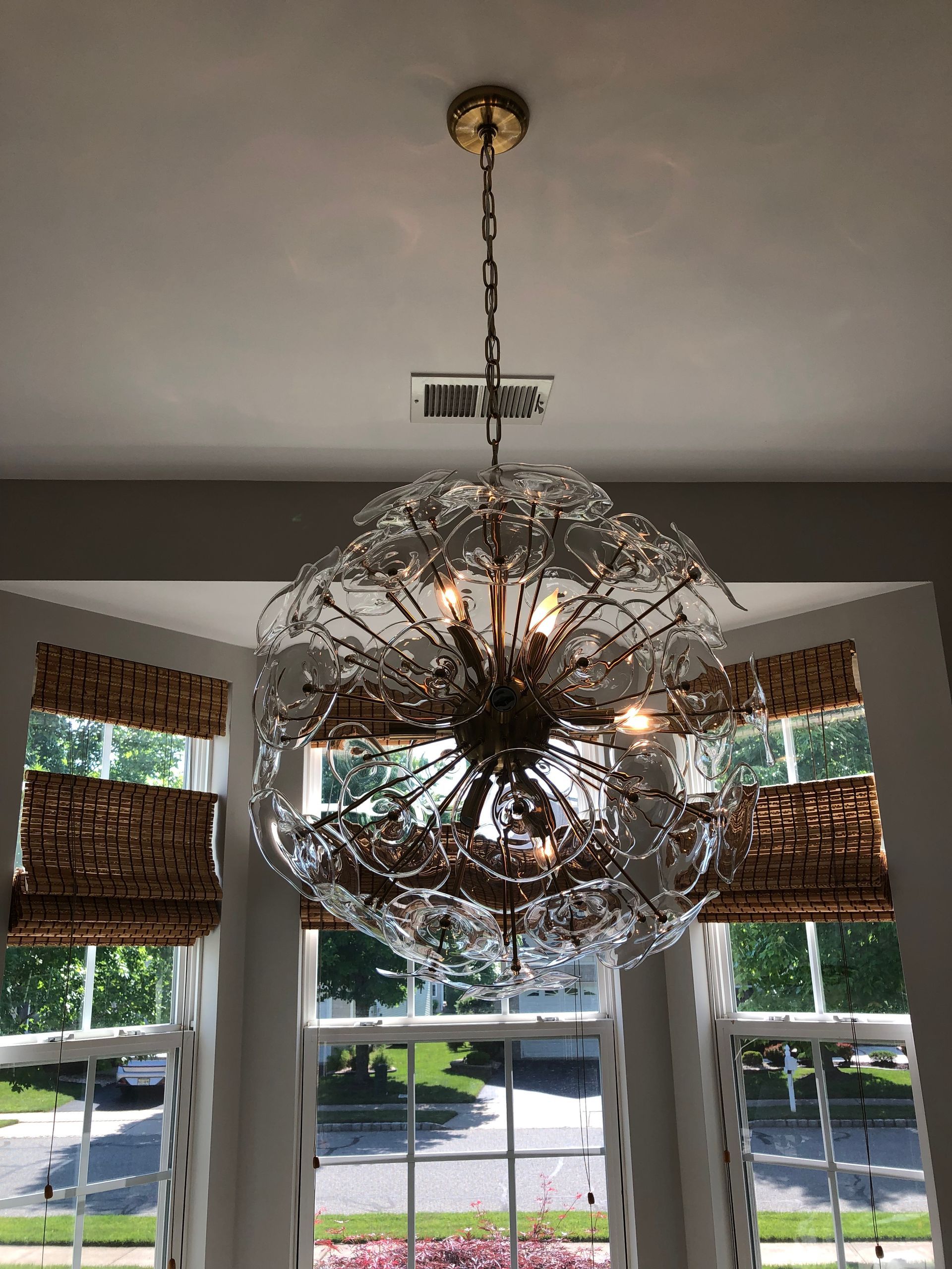 A chandelier is hanging from the ceiling in front of a window.