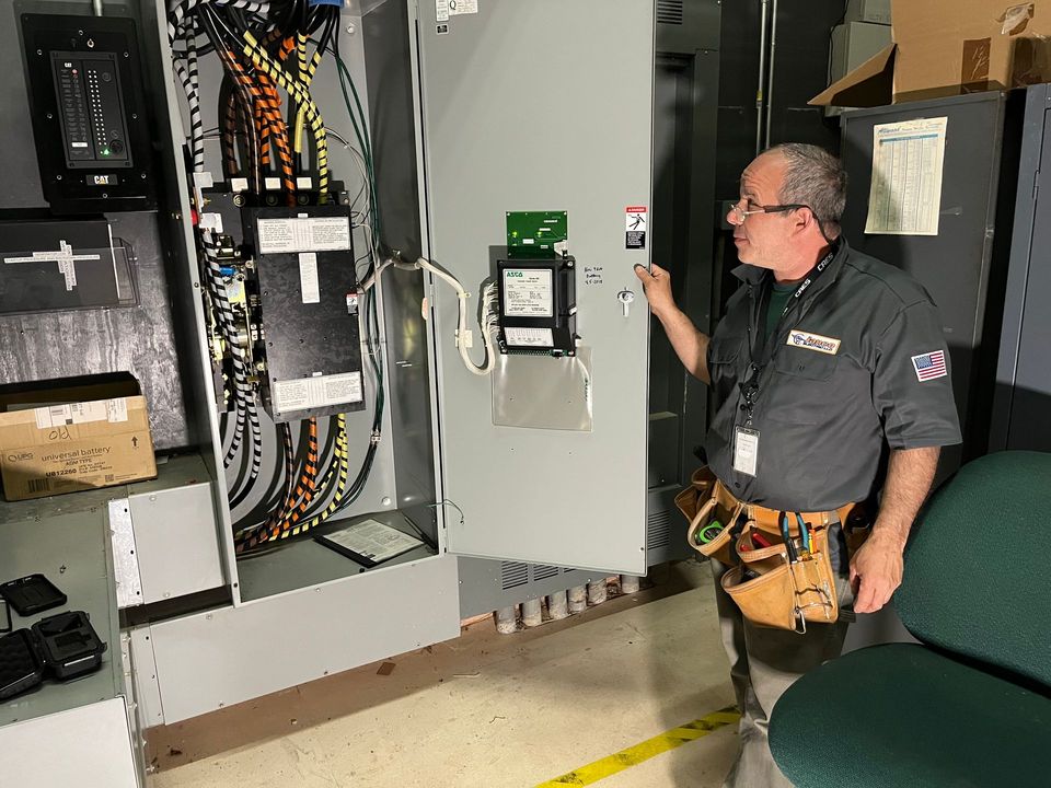 A man is working on an electrical box in a room