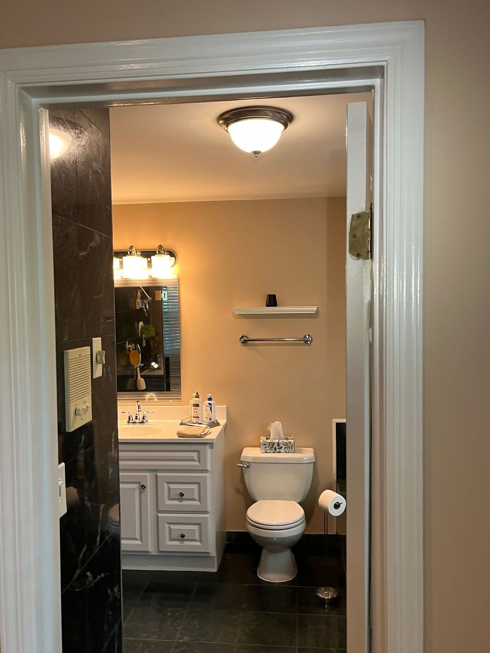 A bathroom with a toilet a sink and a mirror