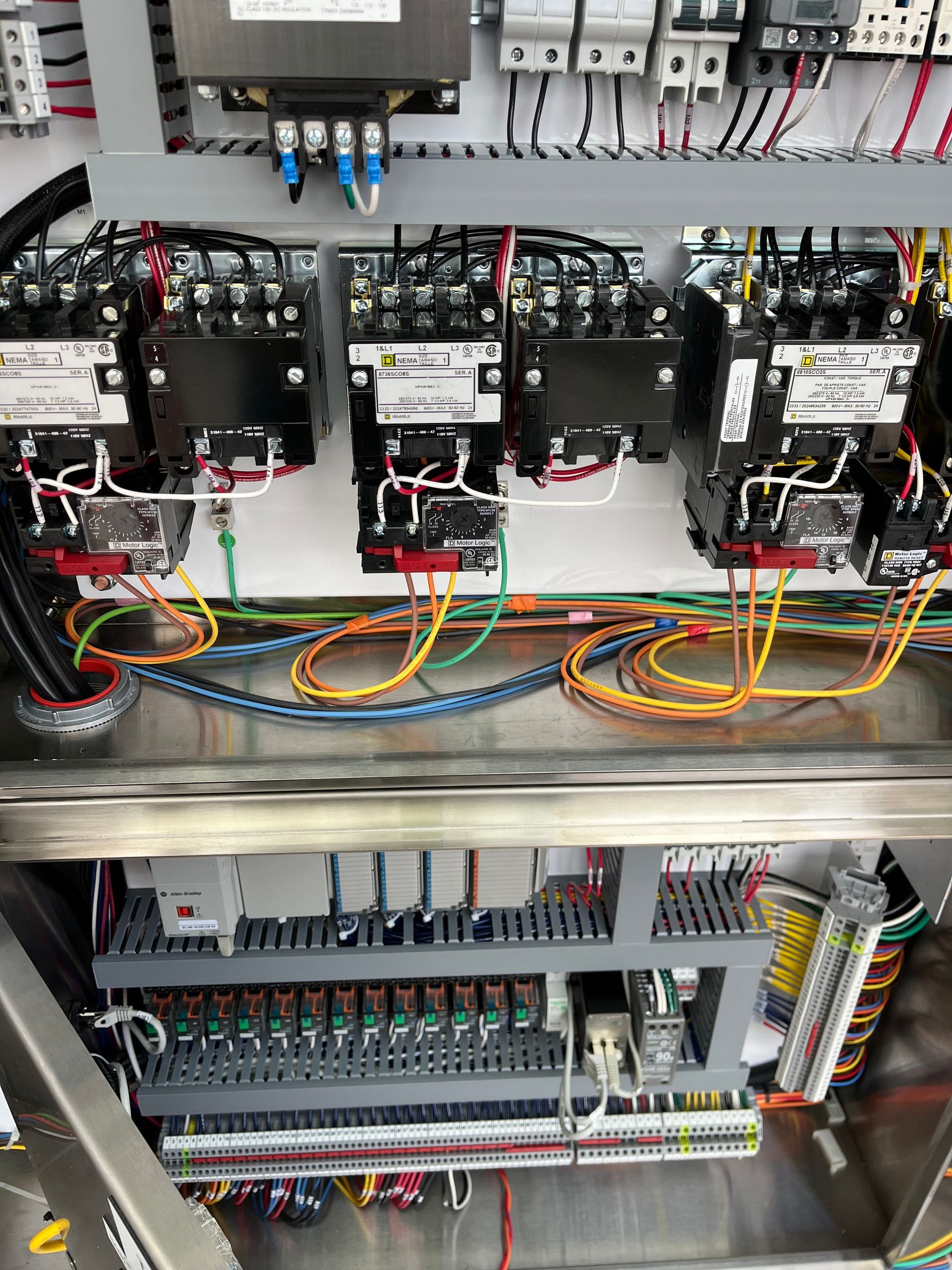 A stainless steel cabinet filled with lots of wires and electrical equipment.