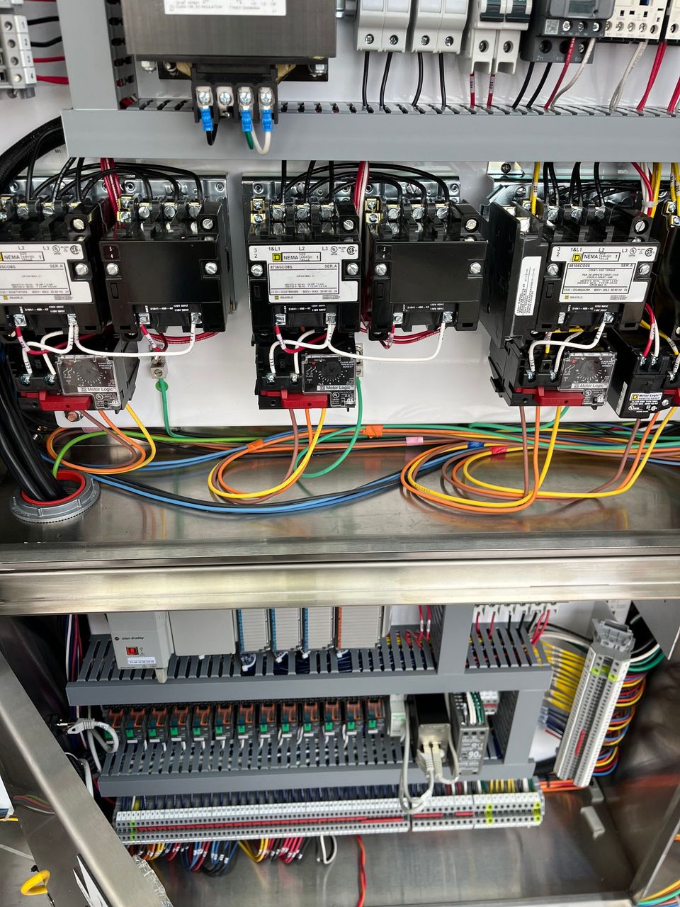 A stainless steel cabinet filled with lots of wires and electrical equipment.