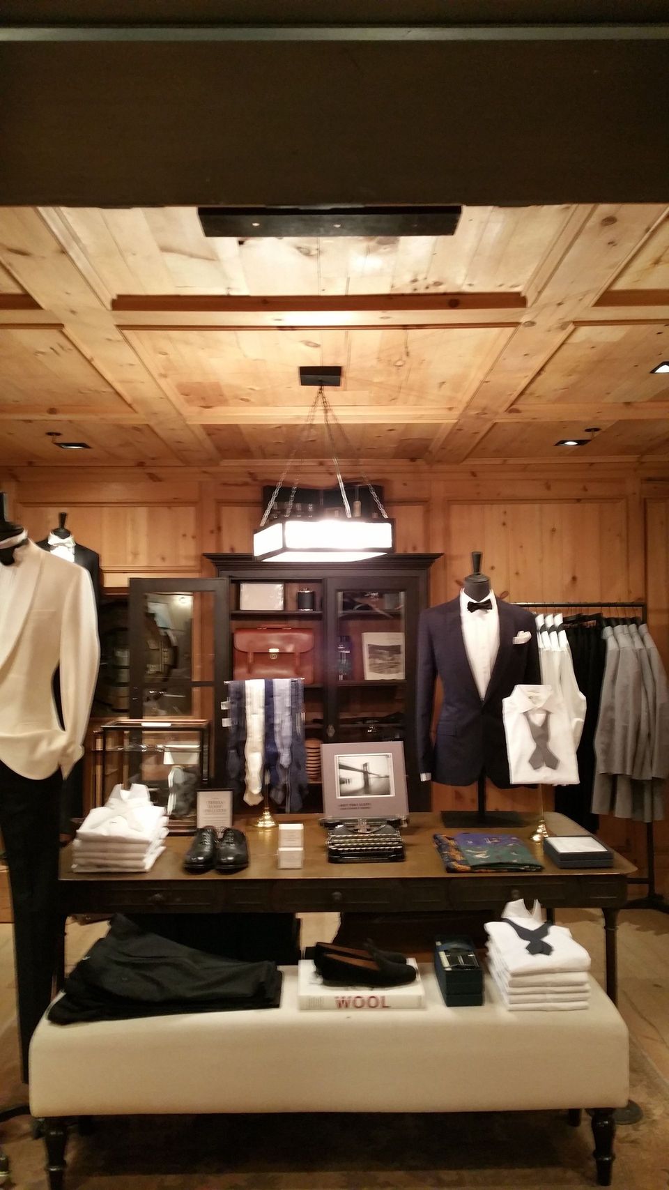 A store with a wooden ceiling and a table with clothes on it