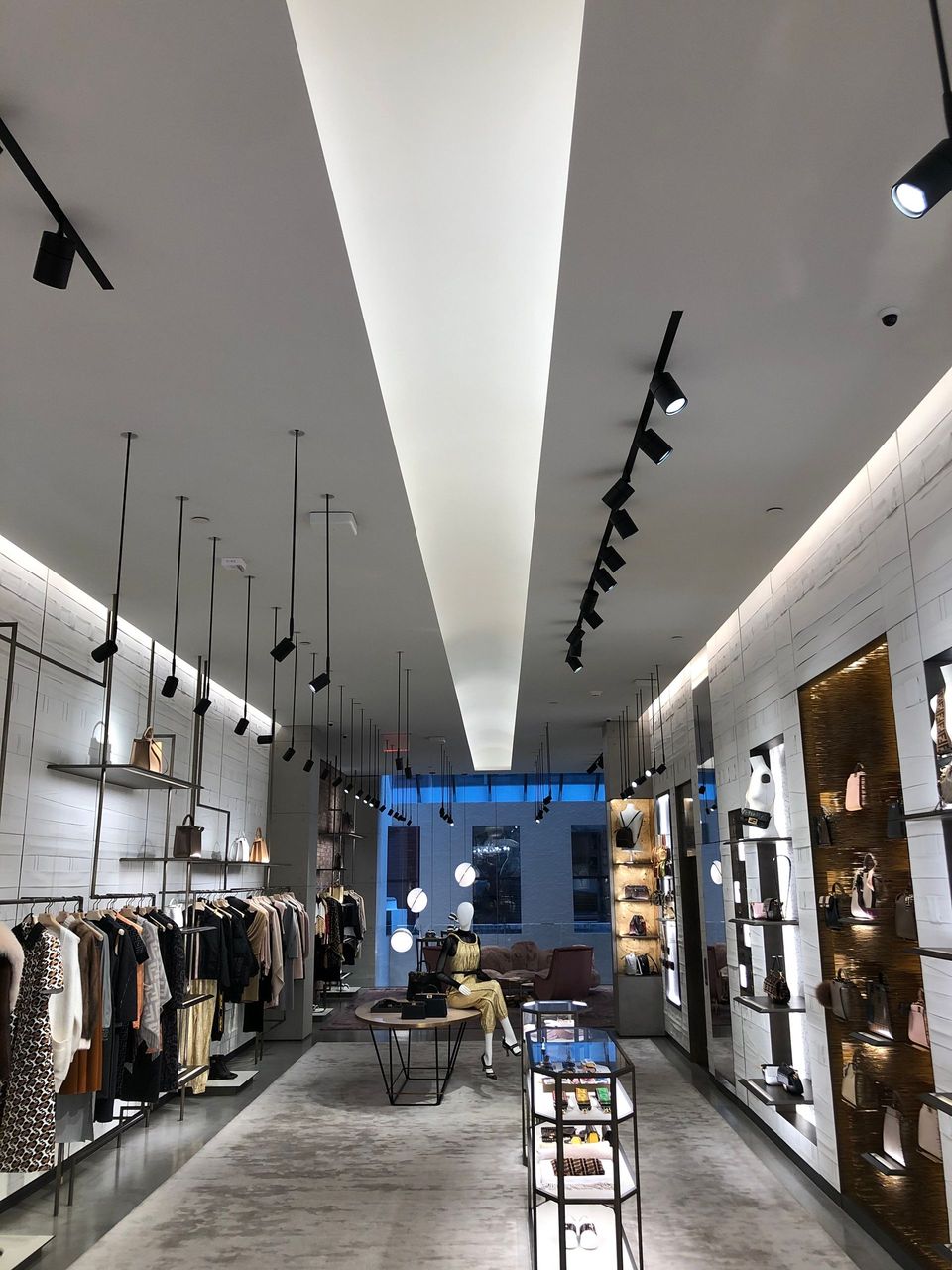 The inside of a clothing store with a ceiling that is very high.