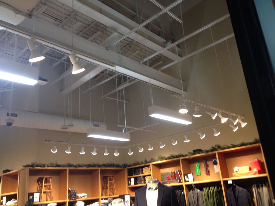 A store with a lot of shelves and lights hanging from the ceiling