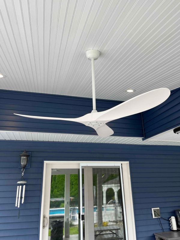 A white ceiling fan is hanging from the ceiling of a blue house.