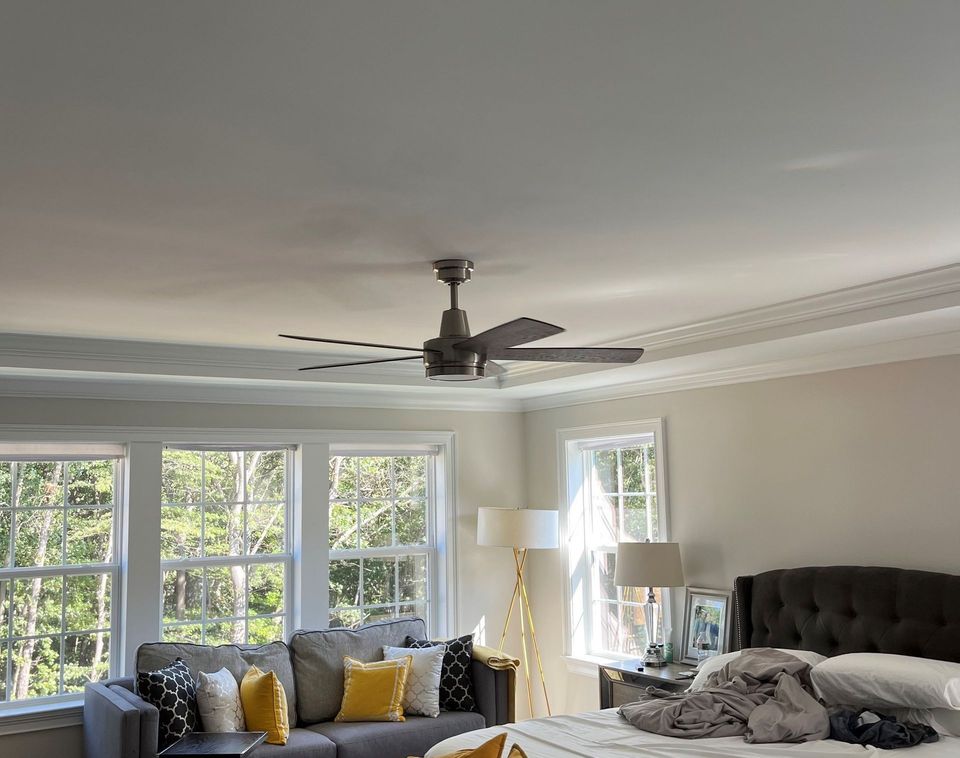 A bedroom with a bed , couch , and ceiling fan