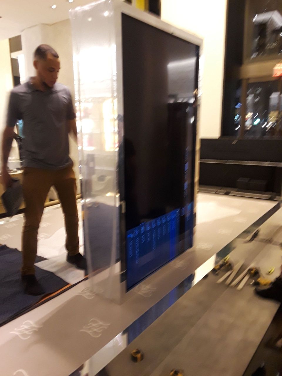 A man is standing in front of a large tv