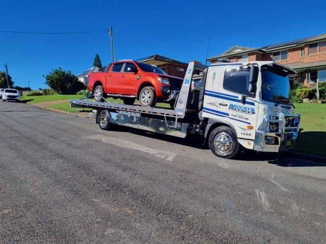 A Tow Truck Driver Loading A Wrecked Car Onto A Tow Truck — Towing in Kempsey