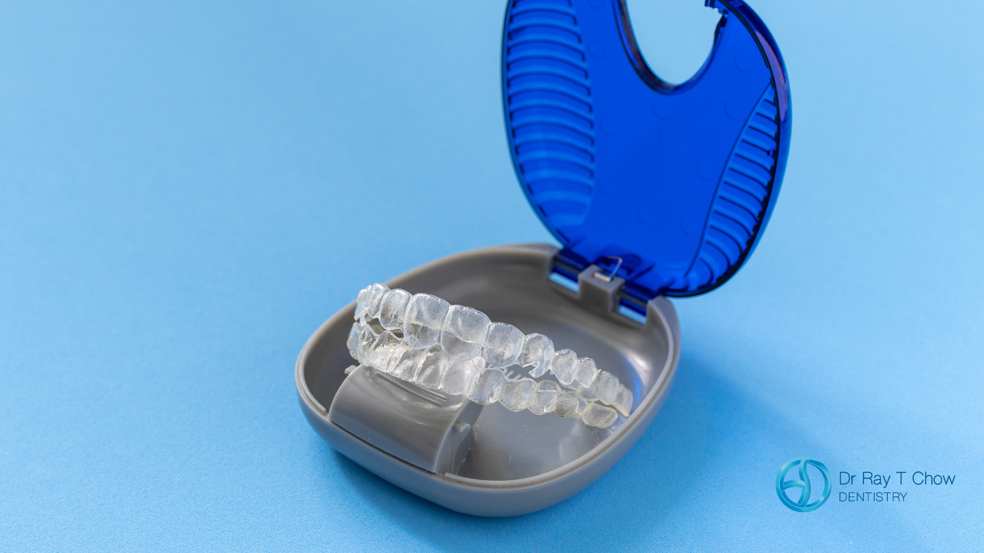 A pair of clear braces in a blue case on a blue surface.