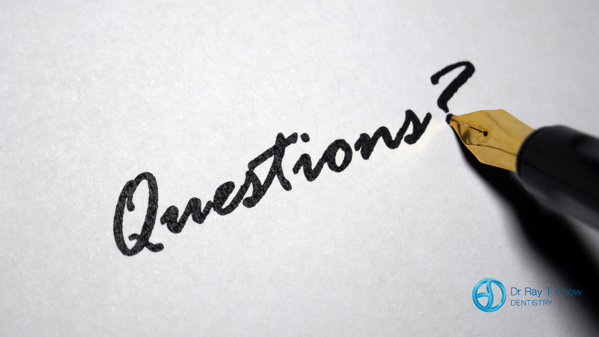 A pen is writing the word questions on a piece of paper