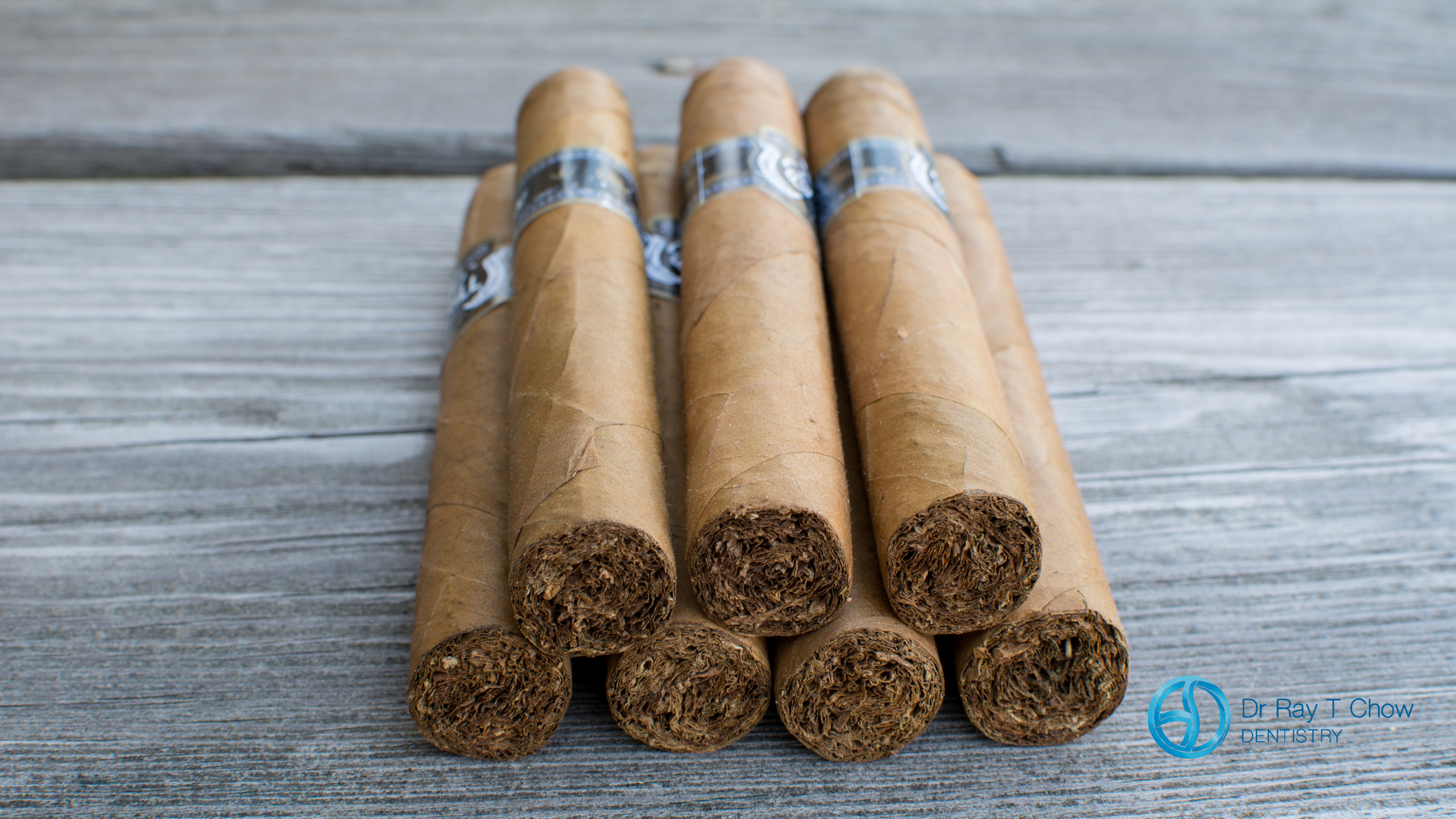 A stack of cigars sitting on top of each other on a wooden table.