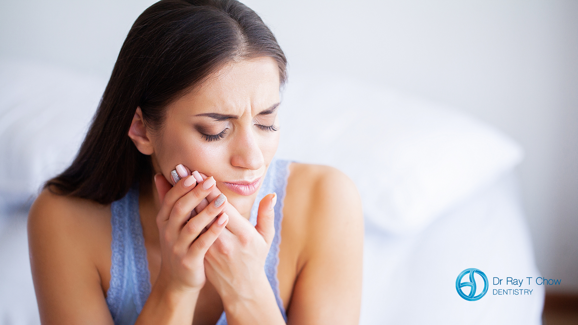A woman is holding her mouth in pain because of a toothache.