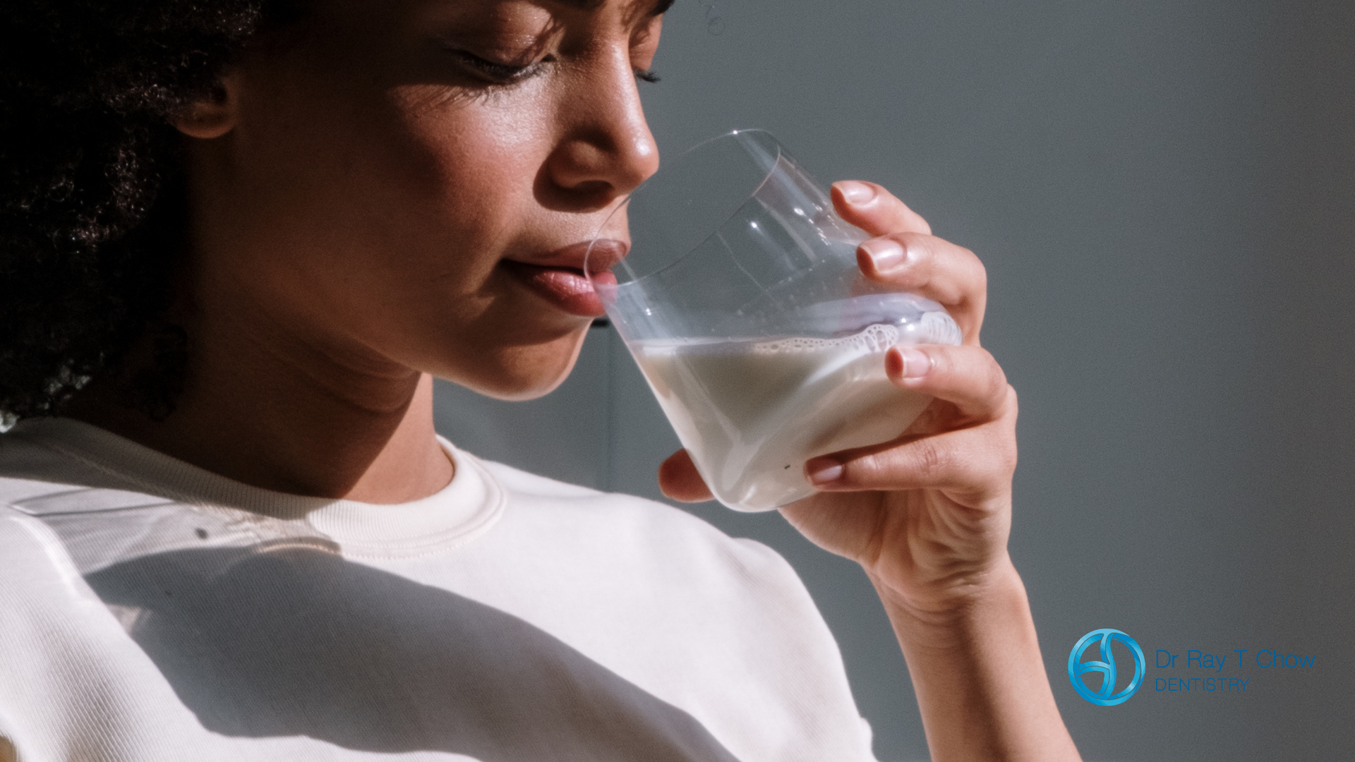 A woman is drinking a glass of milk.