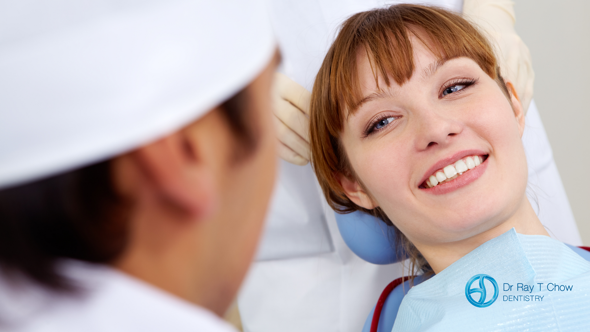 A woman is laying in a dental chair smiling at the dentist.