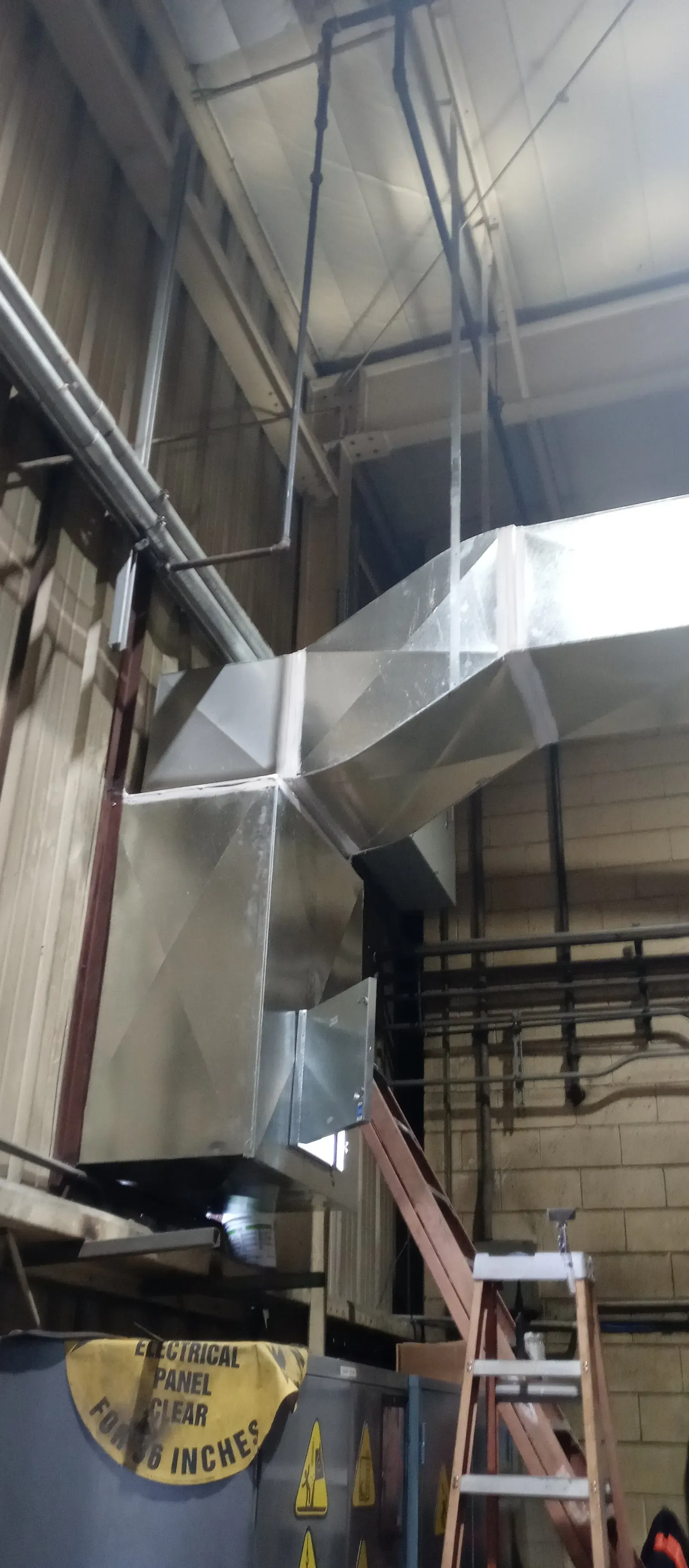 Industrial HVAC ductwork in a warehouse setting.