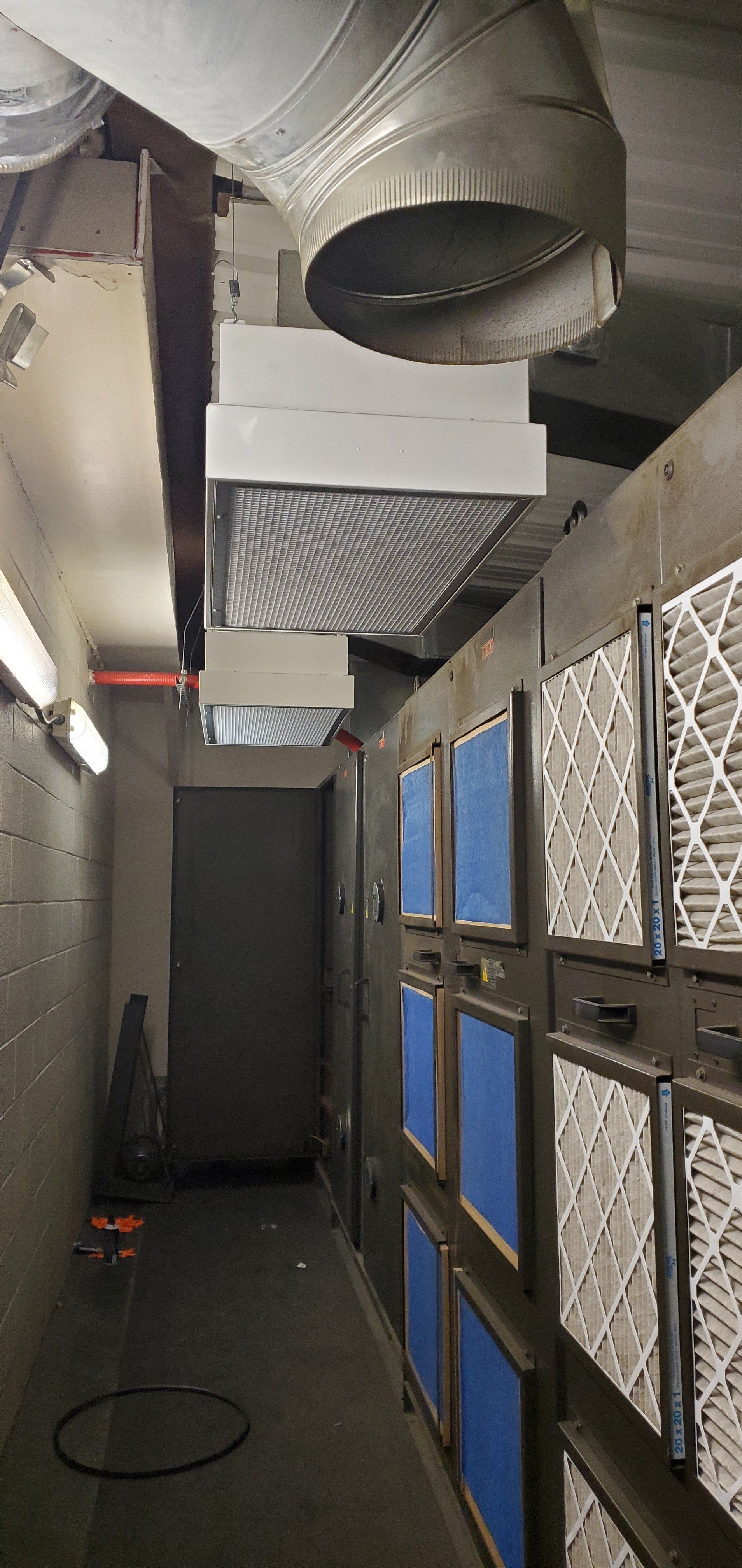 Interior of an industrial spray booth. Filters on the wall, air ducts overhead.