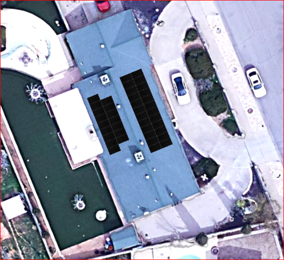 Aerial view of a house with solar panels on the roof. Includes a driveway, cars, and surrounding greenery.