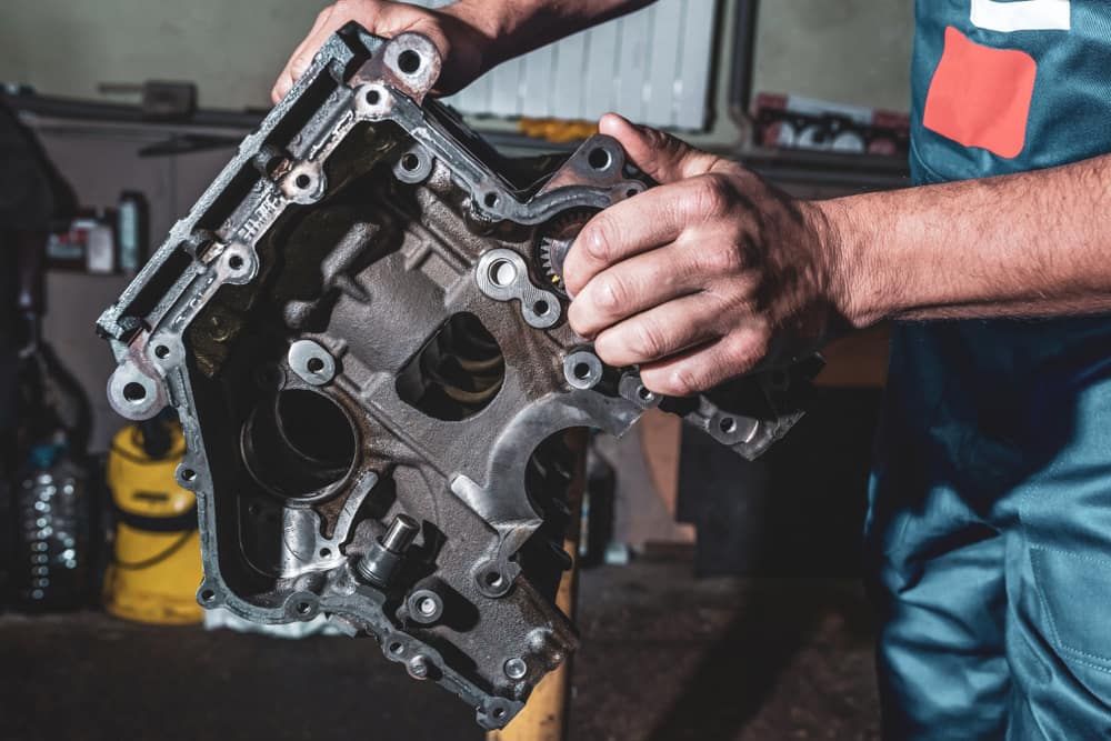 A Man Is Working On A Car Engine In A Garage — Tyrepower Innisfail In Cardwell, QLD