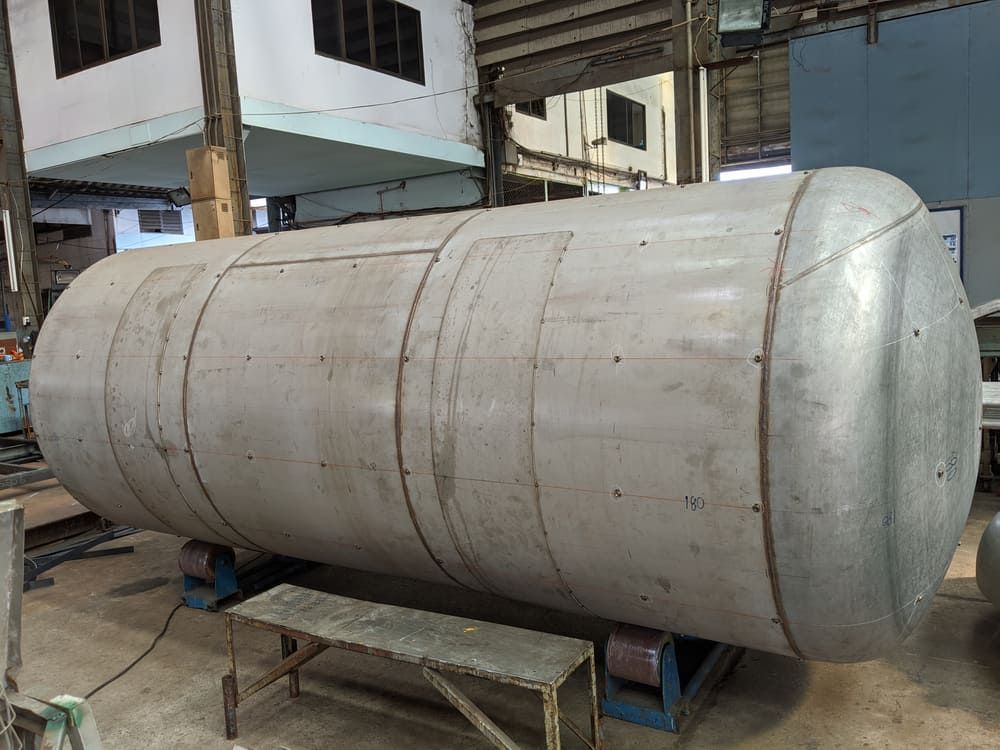 A Large Stainless Steel Tank Is Sitting On Top Of A Wooden Table In A Factory — Tyrepower Innisfail In Goondi Bend, QLD