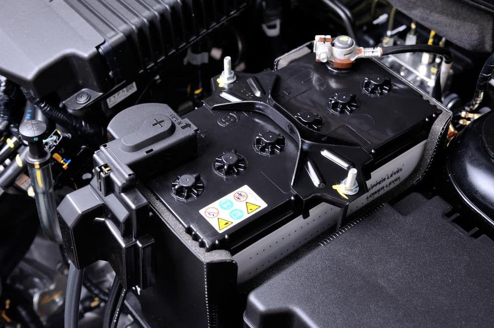 A Car Battery Is Sitting Under The Hood Of A Car — Tyrepower Innisfail In Cardwell, QLD